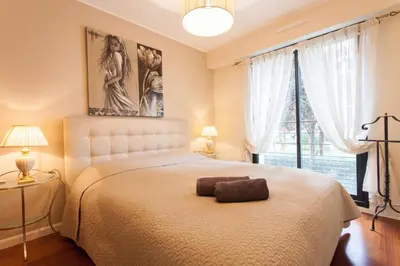 a bedroom with a bed and a large window at Carlton Riviera Apartment in Cannes