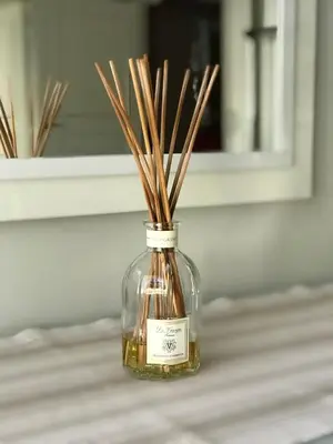 a glass bottle with sticks in it on a table at Carlton Riviera Apartment in Cannes