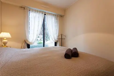 a bedroom with a bed with a pair of slippers on it at Carlton Riviera Apartment in Cannes