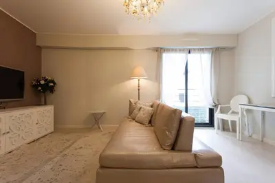 a living room with a couch and a television at Carlton Riviera Apartment in Cannes
