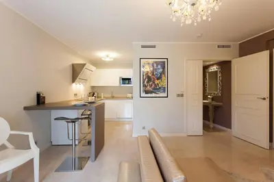 a living room with a couch and a kitchen at Carlton Riviera Apartment in Cannes