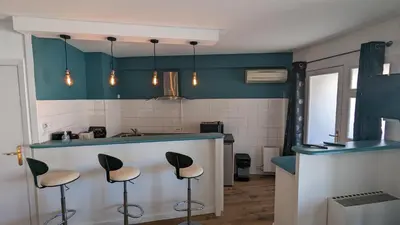 a kitchen with a blue counter and stools at Studio Vieux Port 3 étoiles in Cannes