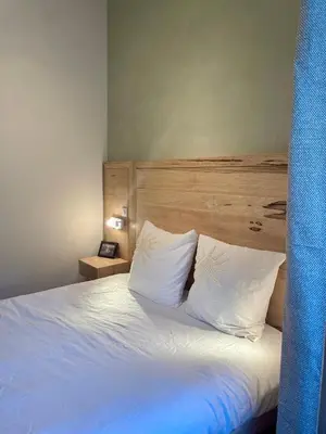 a bedroom with a bed with white sheets and pillows at Duplex rénové avec balcon - Vieux Port Cannes in Cannes