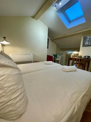a bedroom with a large white bed with a skylight at Duplex rénové avec balcon - Vieux Port Cannes in Cannes