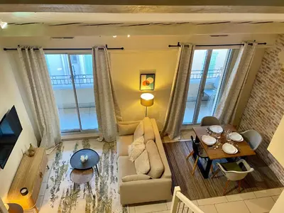 a living room with a couch and a table at Duplex rénové avec balcon - Vieux Port Cannes in Cannes