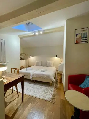 a bedroom with a bed and a table and a couch at Duplex rénové avec balcon - Vieux Port Cannes in Cannes