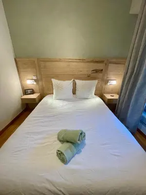 a large white bed with a towel on it at Duplex rénové avec balcon - Vieux Port Cannes in Cannes