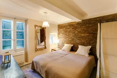 a bedroom with a bed and a brick wall at Florella Félix Faure in Cannes