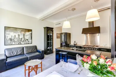 a kitchen and living room with a couch and a table at Florella Félix Faure in Cannes