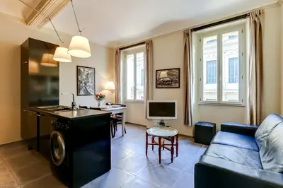 a living room with a blue couch and a table at Florella Félix Faure in Cannes