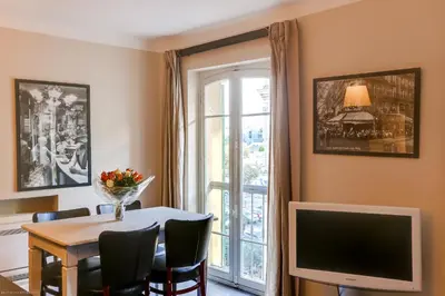 a dining room with a table and a tv and a window at Florella Félix Faure in Cannes
