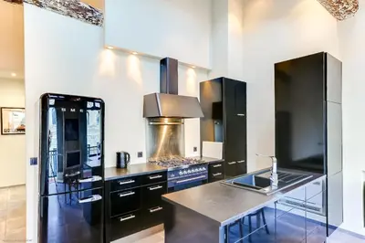 a kitchen with black cabinets and a stove at Florella Félix Faure in Cannes