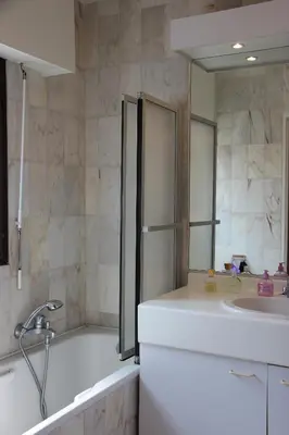 a bathroom with a tub and a sink and a mirror at Central avec Jardin in Cannes