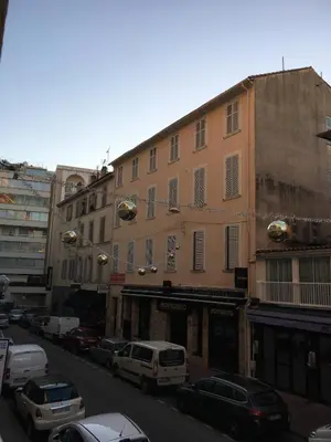 a city street with cars parked in front of buildings at Studio Croisette Cannes in Cannes