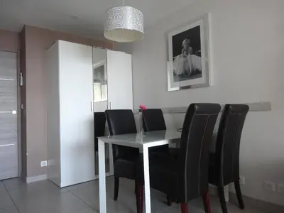 a dining room with a table and black chairs at Cannes design vue mer in Cannes