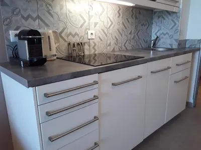a kitchen with white cabinets and a counter top at Cannes design vue mer in Cannes