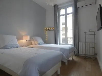 a bedroom with two beds and a window at Happy days, by Welcome to Cannes in Cannes