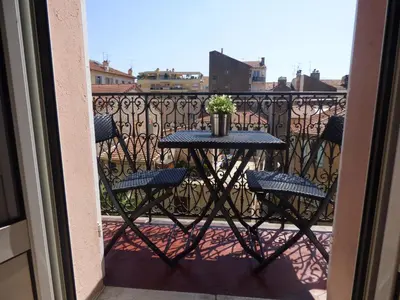 a table with chairs and a plant on a balcony at Happy days, by Welcome to Cannes in Cannes