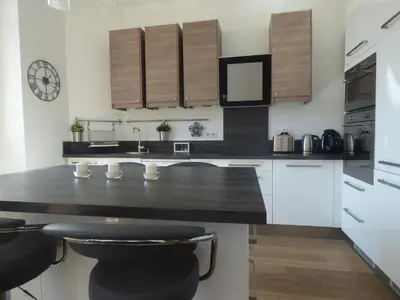 a kitchen with white cabinets and a black counter top at Happy days, by Welcome to Cannes in Cannes