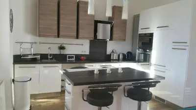 a kitchen with white cabinets and a black counter top at Happy days, by Welcome to Cannes in Cannes