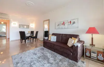 a living room with a couch and a dining room at Sea Side apartment in Cannes