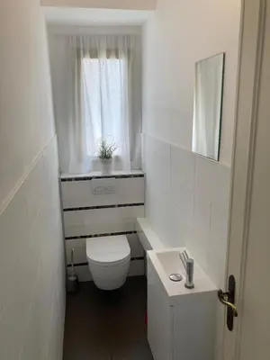 a white bathroom with a toilet and a window at Sea Side apartment in Cannes