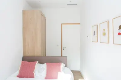 a bedroom with a bed with pink and white pillows at Cannes Le Chabaud in Cannes