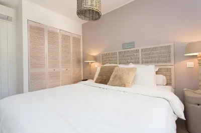 a white bedroom with a large white bed at Maria Sea Cannes in Cannes