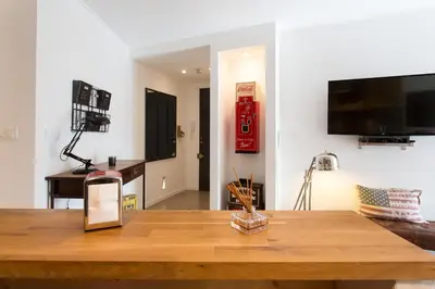 a living room with a table and a television on a wall at Maria Sea Cannes in Cannes