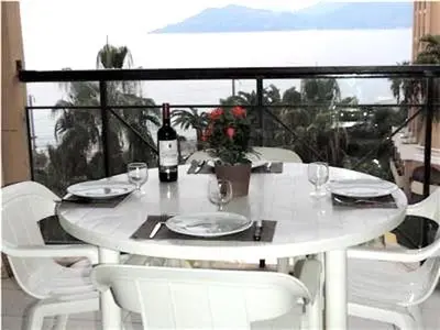 a white table with white chairs and a bottle of wine at Cannes Front Beach Pools Apartment in Cannes
