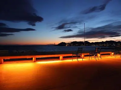 a group of chairs sitting on the beach at sunset at Cannes Front Beach Pools Apartment in Cannes