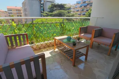 a balcony with two chairs and a table on a patio at Central Park Apartment in Cannes