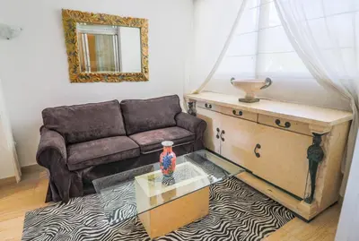 a living room with a couch and a glass table at Central Park Apartment in Cannes