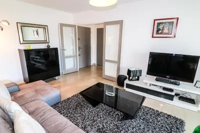 a living room with a couch and a flat screen tv at Central Park Apartment in Cannes