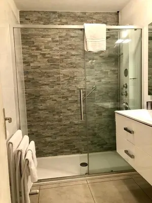 a bathroom with a shower with a glass door at Central Park Apartment in Cannes