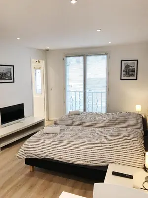 a bedroom with a large bed and a large window at Studio Carré d'or Cannes in Cannes