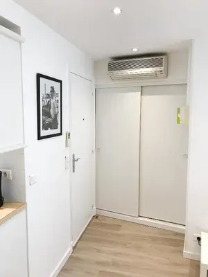 a living room with white walls and a white closet at Studio Carré d'or Cannes in Cannes