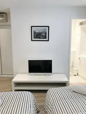 a living room with a tv on a white wall at Studio Carré d'or Cannes in Cannes