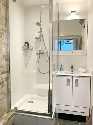 a white bathroom with a shower and a sink at Studio Carré d'or Cannes in Cannes
