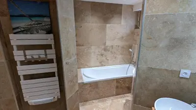 a bathroom with a tub and a toilet and a sink at Eden Park 3 pièces 4 étoiles 100m des Plages Piscines SPA Parking in Cannes