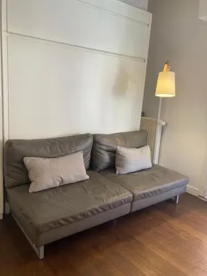 a couch in a living room with two pillows on it at Cannes City B&B in Cannes