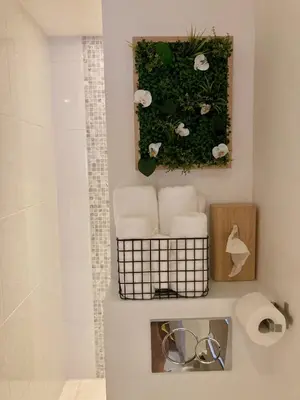 a bathroom with towels and flowers on a wall at Cannes City B&B in Cannes
