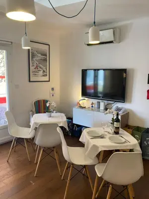 a dining room with two tables and a flat screen tv at Cannes City B&B in Cannes