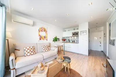 a living room with a white couch and a kitchen at STUDIO by the croisette in Cannes