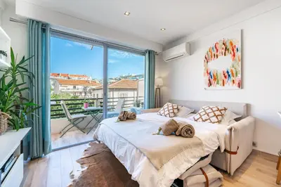 a bedroom with a bed and a large window at STUDIO by the croisette in Cannes