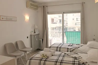 a bedroom with two beds and a window with a balcony at Viva Riviera Cosy and Large 2 Bedrooms with balcony in Cannes
