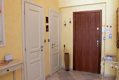 a hallway with a wooden door and a kitchen at Viva Riviera Cosy and Large 2 Bedrooms with balcony in Cannes