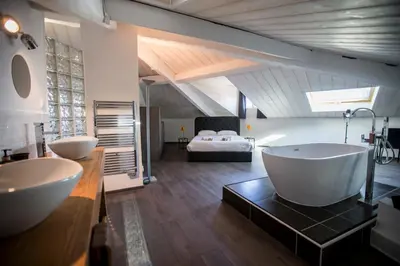 a bathroom with two sinks and a bed in the background at Sherlock Loft by Connexion in Cannes
