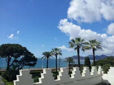 a cemetery with palm trees and the ocean in the background at Villa Belle Rive in Cannes