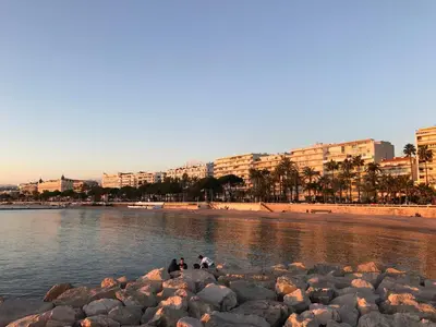 a group of people sitting on rocks on the beach at Close Palais - Calm - Brand New in Cannes